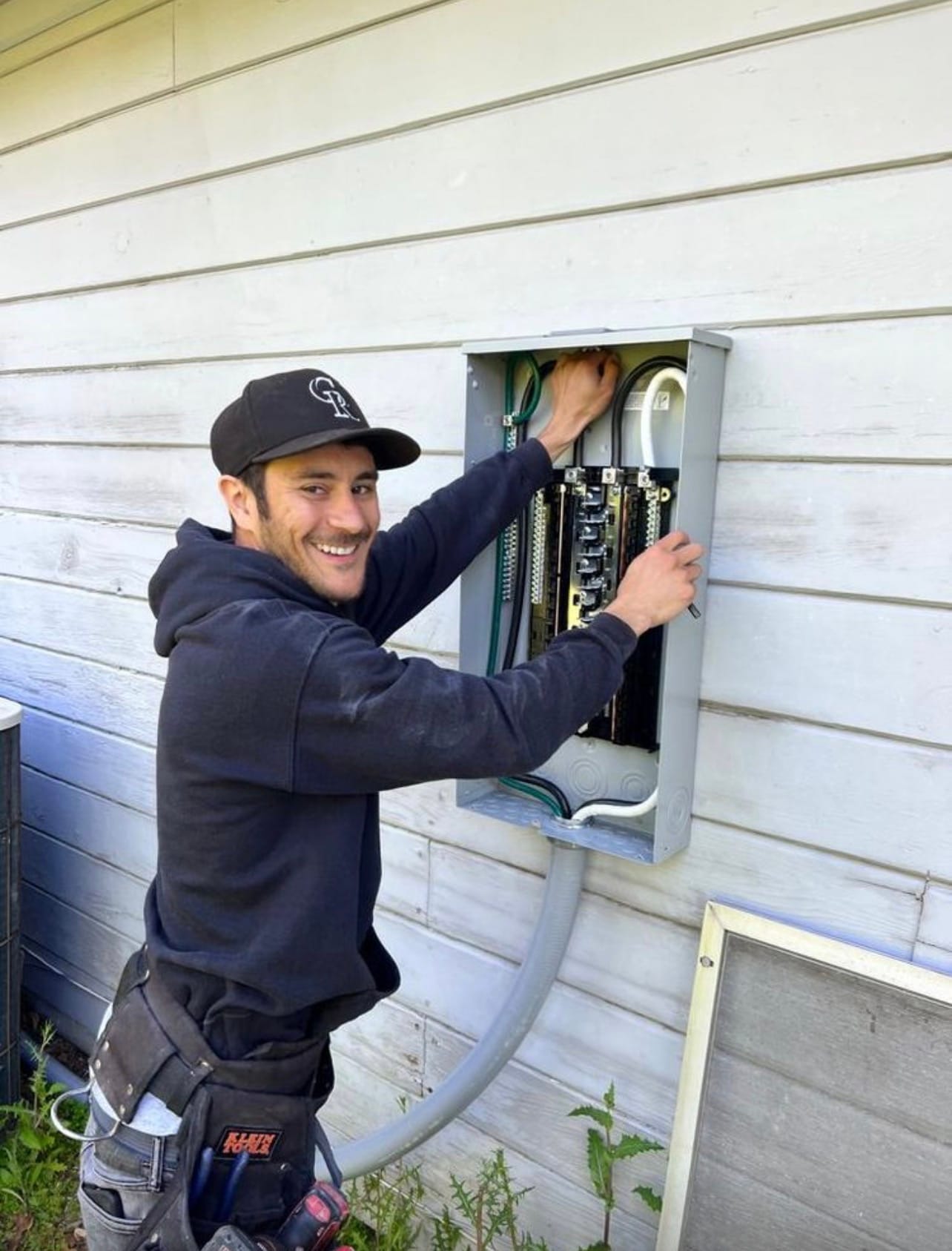 AQE technician beside an open electrical panel