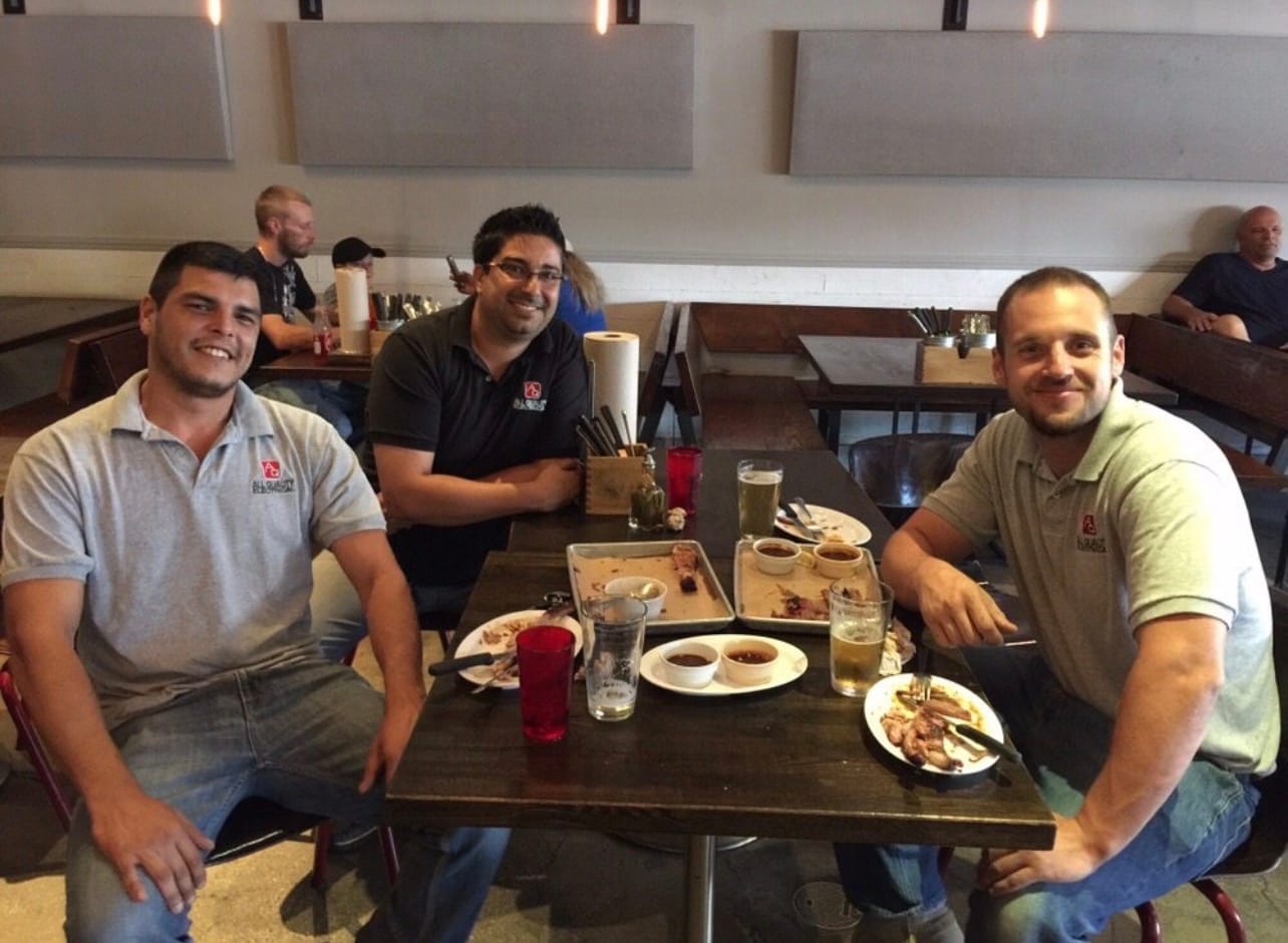 Three AQE crew members having lunch together at a restaurant