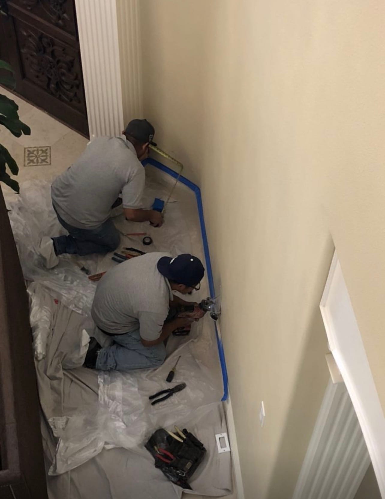 Two technicians installing an outlet during a remodel