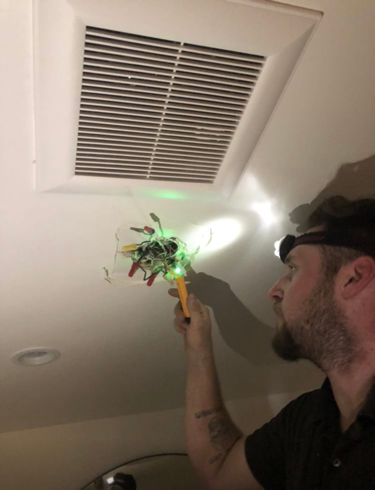 Technician testing a bathroom exhaust fan connection