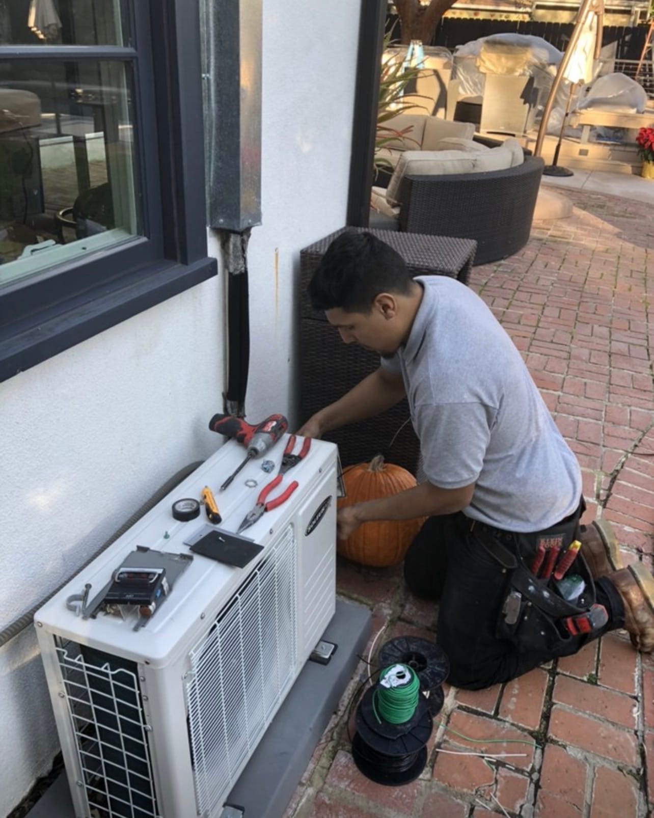 Technician wiring an outdoor condenser unit
